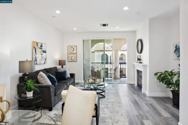 a living room with furniture a wooden floor and a chandelier