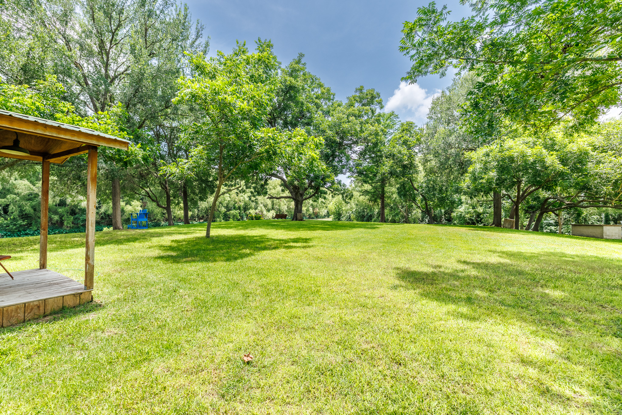 Tbd Goodwin Road Gonzales, TX 78629 - Photo 15 of 33 Green grounds with mature trees and a shaded wooden deck for outdoor enjoyment.