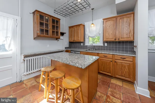 a kitchen with stainless steel appliances granite countertop wooden cabinets a sink and a window