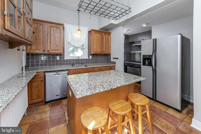 a kitchen with stainless steel appliances granite countertop a sink refrigerator and microwave