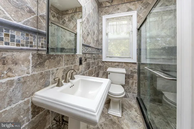 a bathroom with a sink a toilet and a mirror