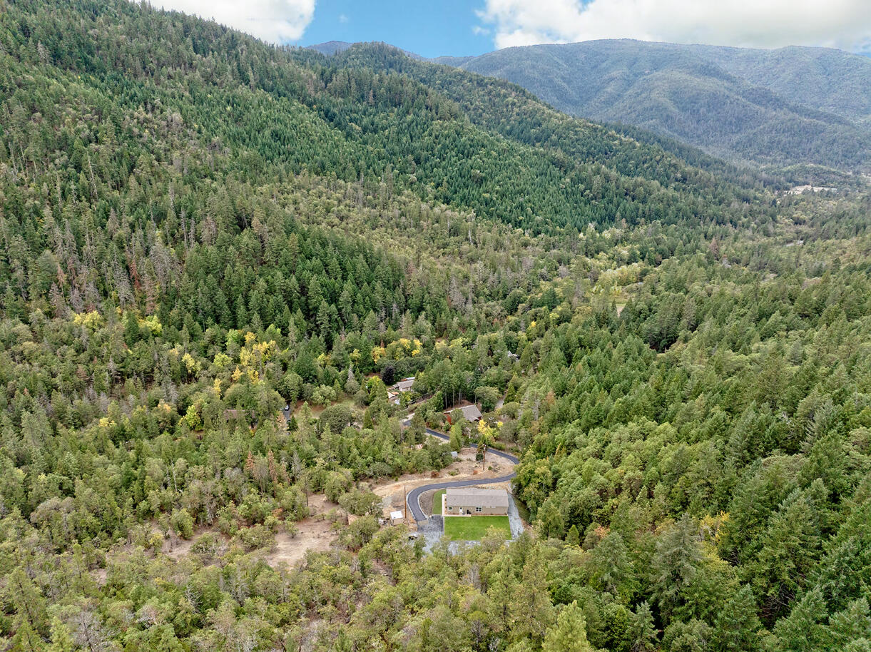 5572 Jumpoff Joe Creek Road Grants Pass, OR 97526 - Photo 25 of 38 a view of a lush green forest with a building