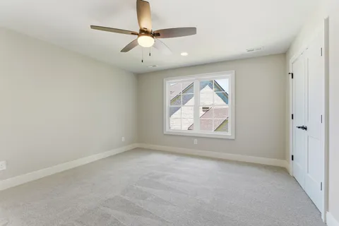 an empty room with windows and fan