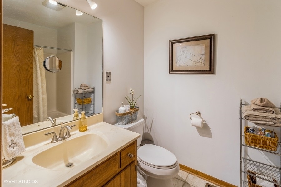 155 Forestview Drive Elgin, IL 60120 - Photo 25 of 36 a bathroom with a sink vanity mirror and toilet