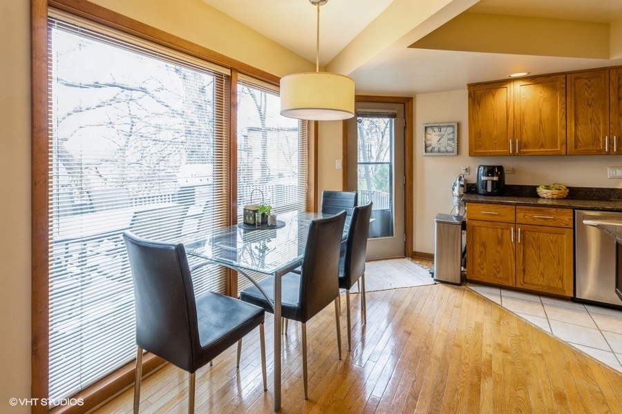 155 Forestview Drive Elgin, IL 60120 - Photo 6 of 36 a dining room with furniture a chandelier and wooden floor