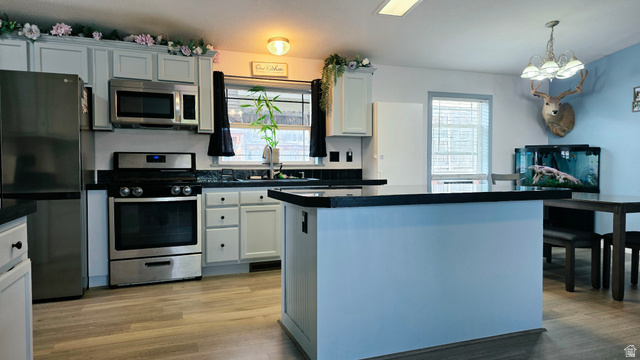 401 West 2000th Street South Vernal, UT 84078 - Photo 14 of 26 Kitchen featuring light-finish cabinetry with black hardware, black countertops, and a full suite of stainless steel appliances