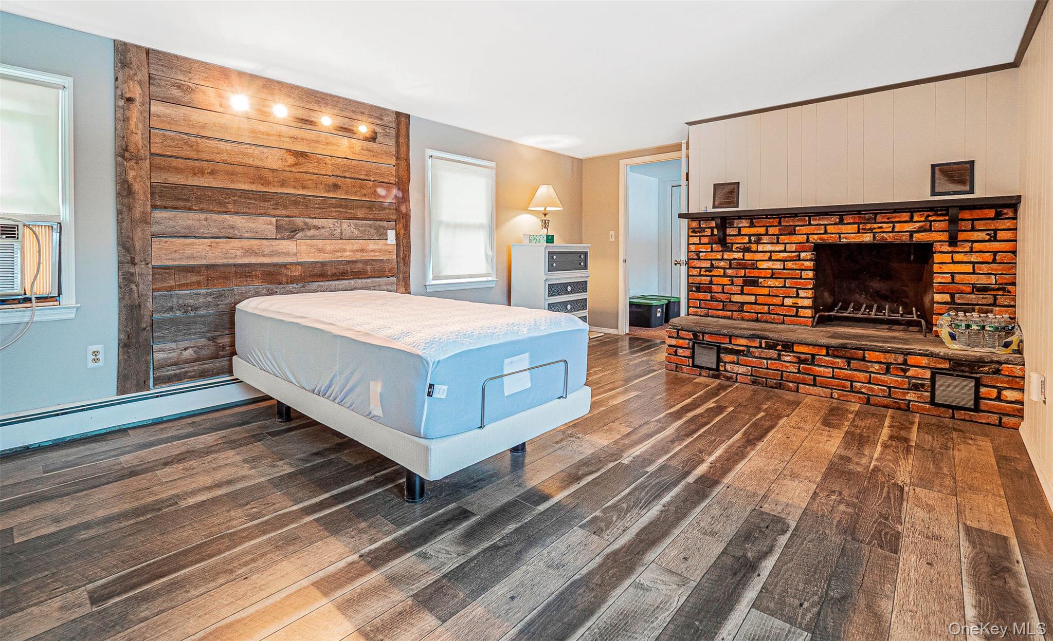 238 South Centerville Road Middletown, NY 10940 - Photo 15 of 30 Bedroom featuring wood finished floors, a brick fireplace, an accent wall,