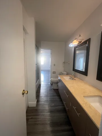 a large bathroom with a granite countertop sink a mirror and a bathtub
