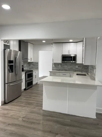a kitchen with stainless steel appliances a refrigerator sink and microwave