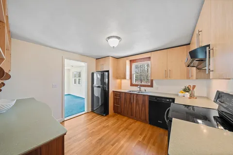 a kitchen with stainless steel appliances granite countertop a refrigerator and a stove top oven