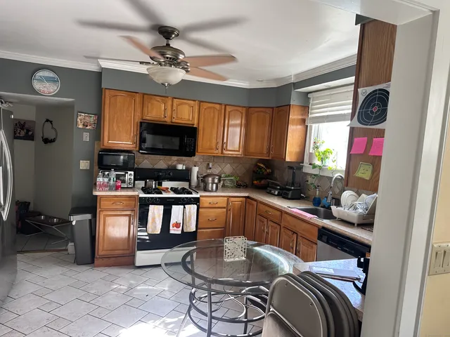 a kitchen with stainless steel appliances kitchen island granite countertop a refrigerator and a stove top oven