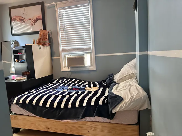 a bed sitting in a bedroom next to a window