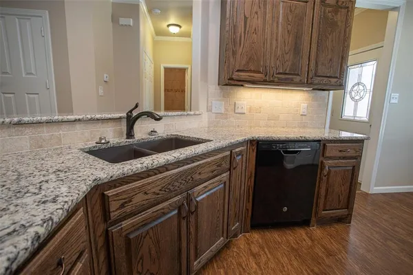a kitchen with granite countertop a sink and a wooden cabinets