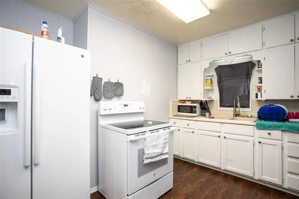 a kitchen with white cabinets and white appliances