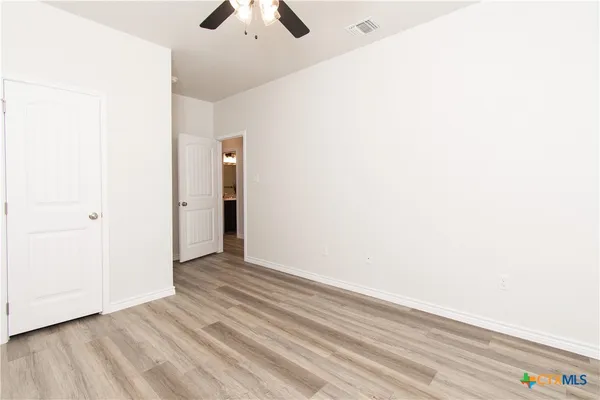 a view of an empty room with wooden floor