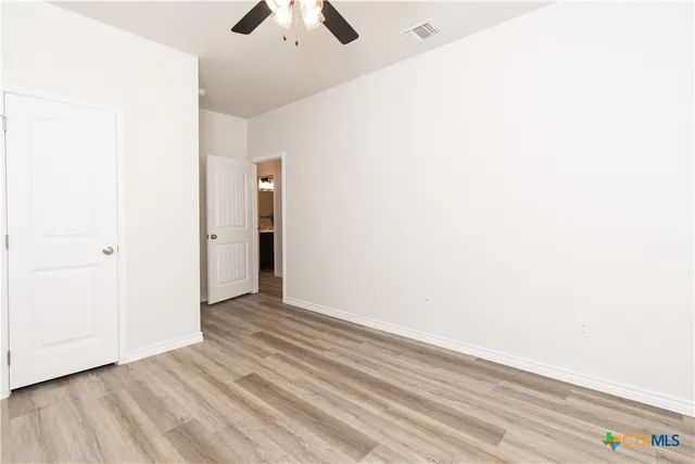 a view of an empty room with wooden floor