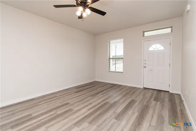 wooden floor in an empty room with a window