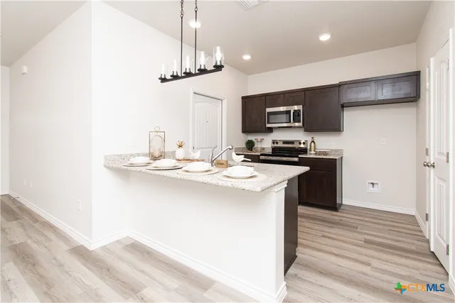a kitchen with stainless steel appliances a sink stove and refrigerator