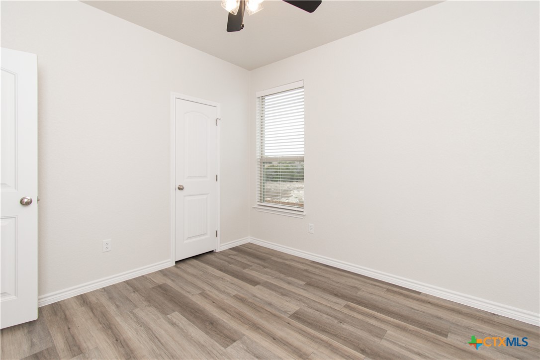 121 Leon Lane, Unit B Copperas Cove, TX 76522 - Photo 8 of 18 an empty room with ceiling fan and windows