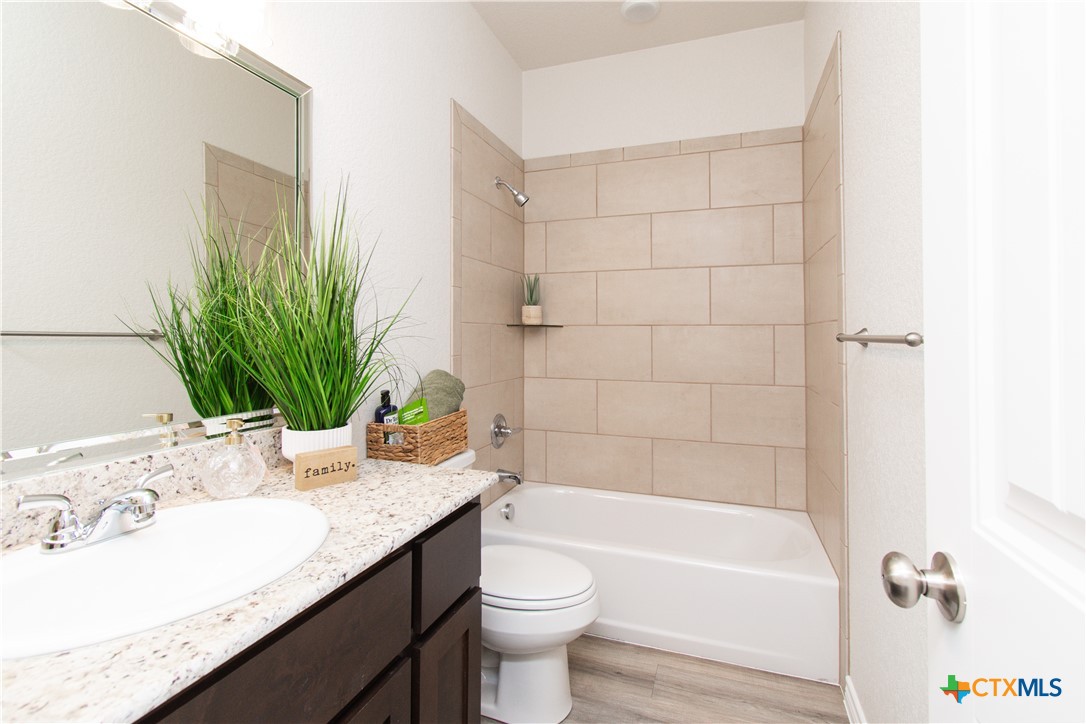 121 Leon Lane, Unit B Copperas Cove, TX 76522 - Photo 10 of 18 a bathroom with a granite countertop sink a toilet and bathtub
