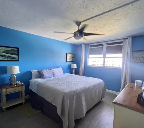 a bedroom with a bed and a lamp with the wooden floor