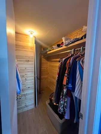 a view of walk in closet with clothes and shoes