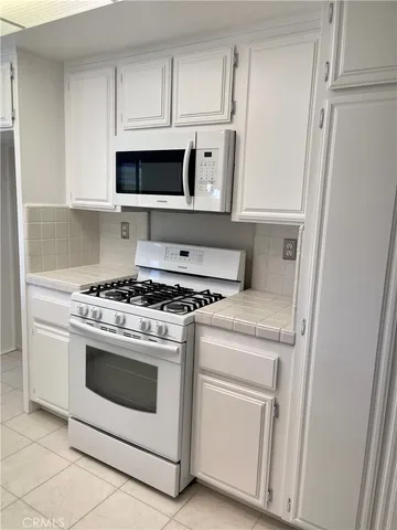 a stove top oven sitting inside of a kitchen