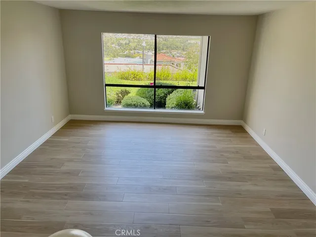 a view of a room with wooden floor and a window