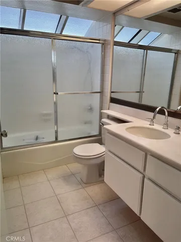 a bathroom with a granite countertop sink toilet a mirror and shower