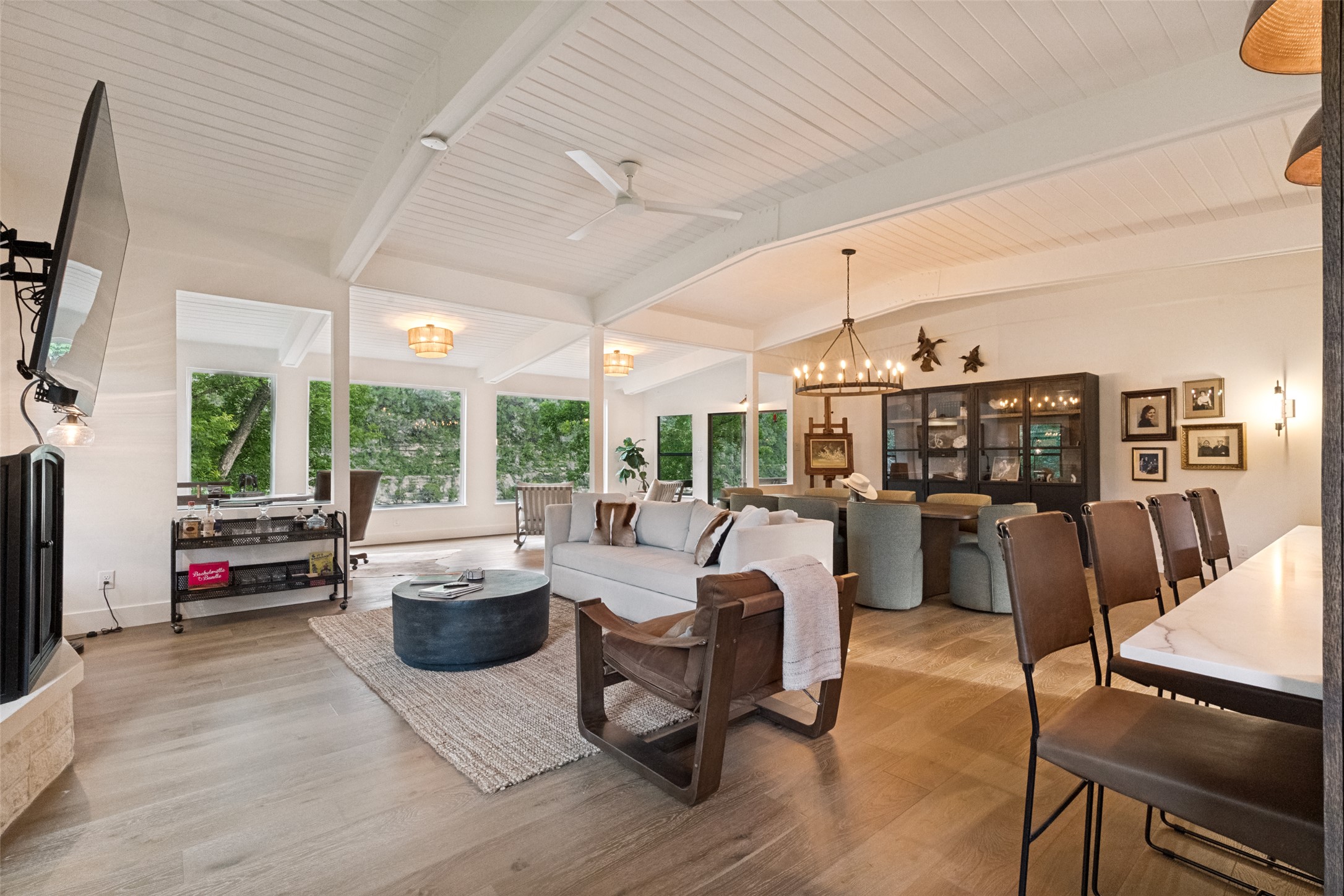 303 Lago Verde Road Austin, TX 78734 - Photo 11 of 39 Elegant living and dining converge under soaring vaulted ceilings, illuminated by expansive windows.