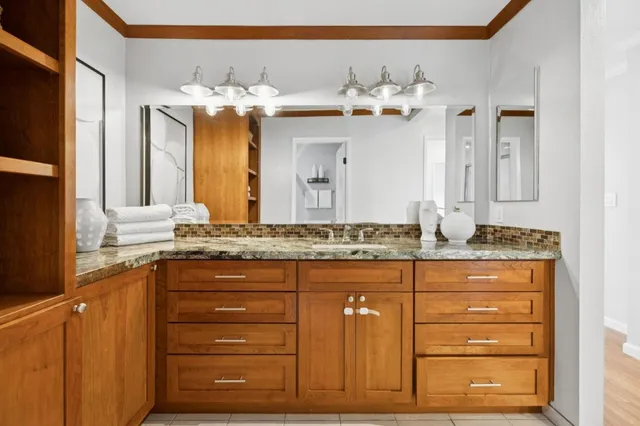 a bathroom with a granite countertop sink and a mirror