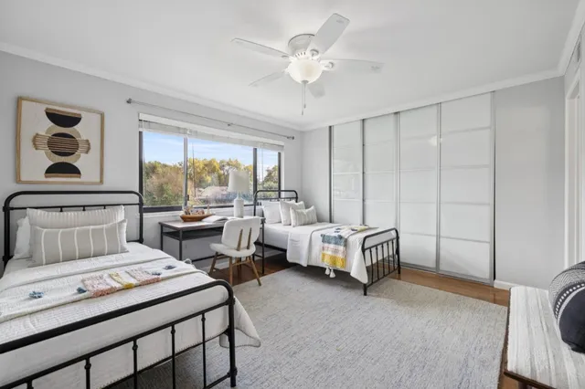 a spacious bedroom with a bed a couch and large window