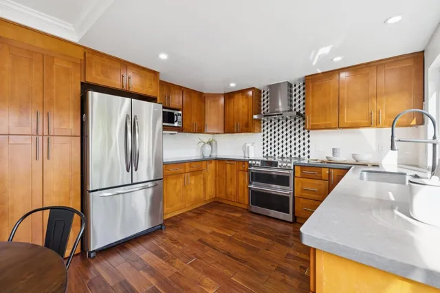 a kitchen with stainless steel appliances granite countertop a refrigerator a sink and a stove