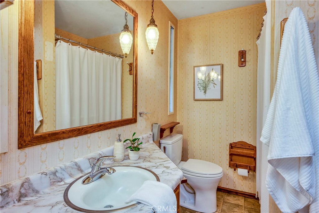 7723 Cora Drive Lucerne, CA 95458 - Photo 21 of 56 a bathroom with a granite countertop toilet sink and mirror
