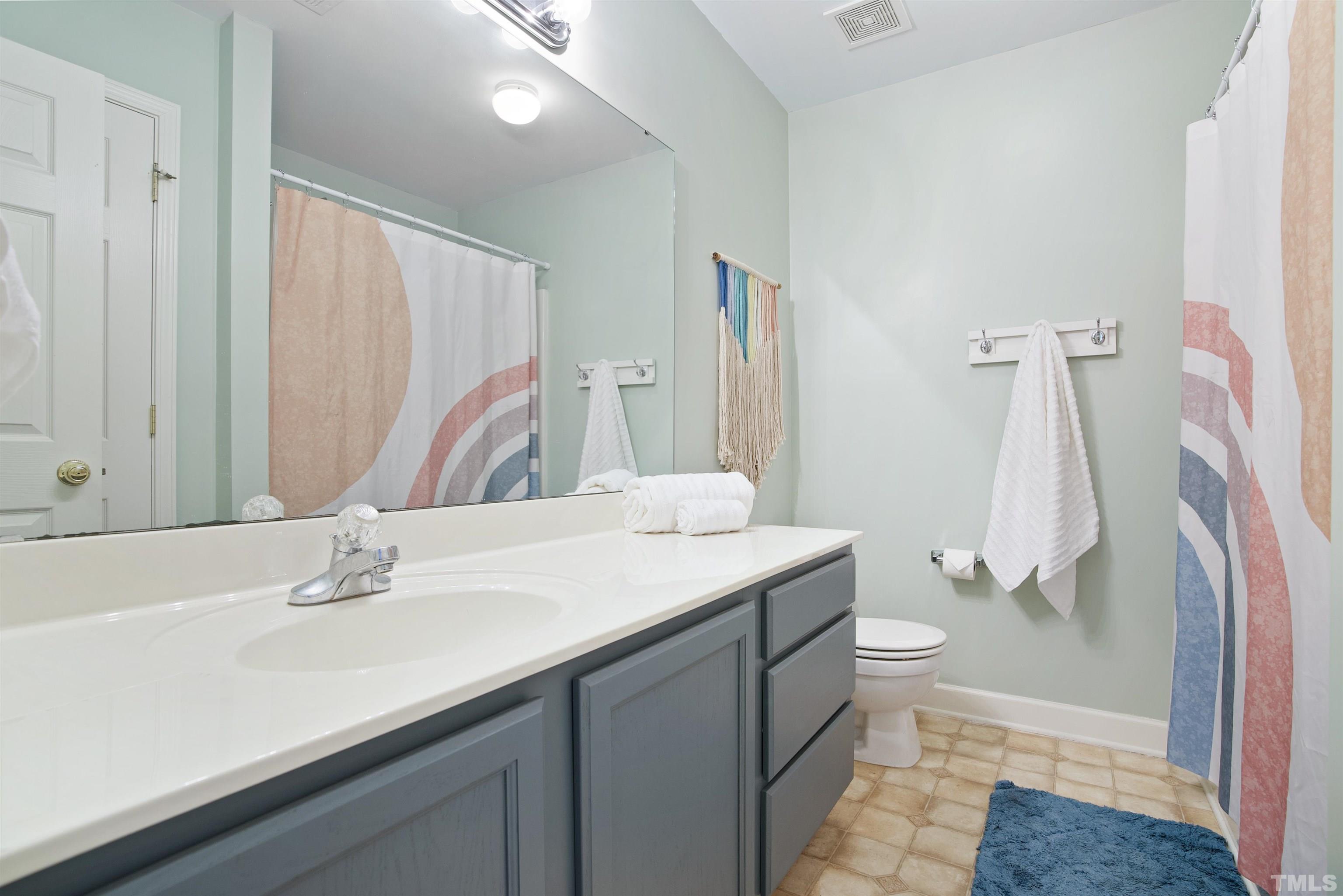 3421 Suncrest Village Lane Raleigh, NC 27616 - Photo 20 of 29 a bathroom with a sink a toilet and a mirror