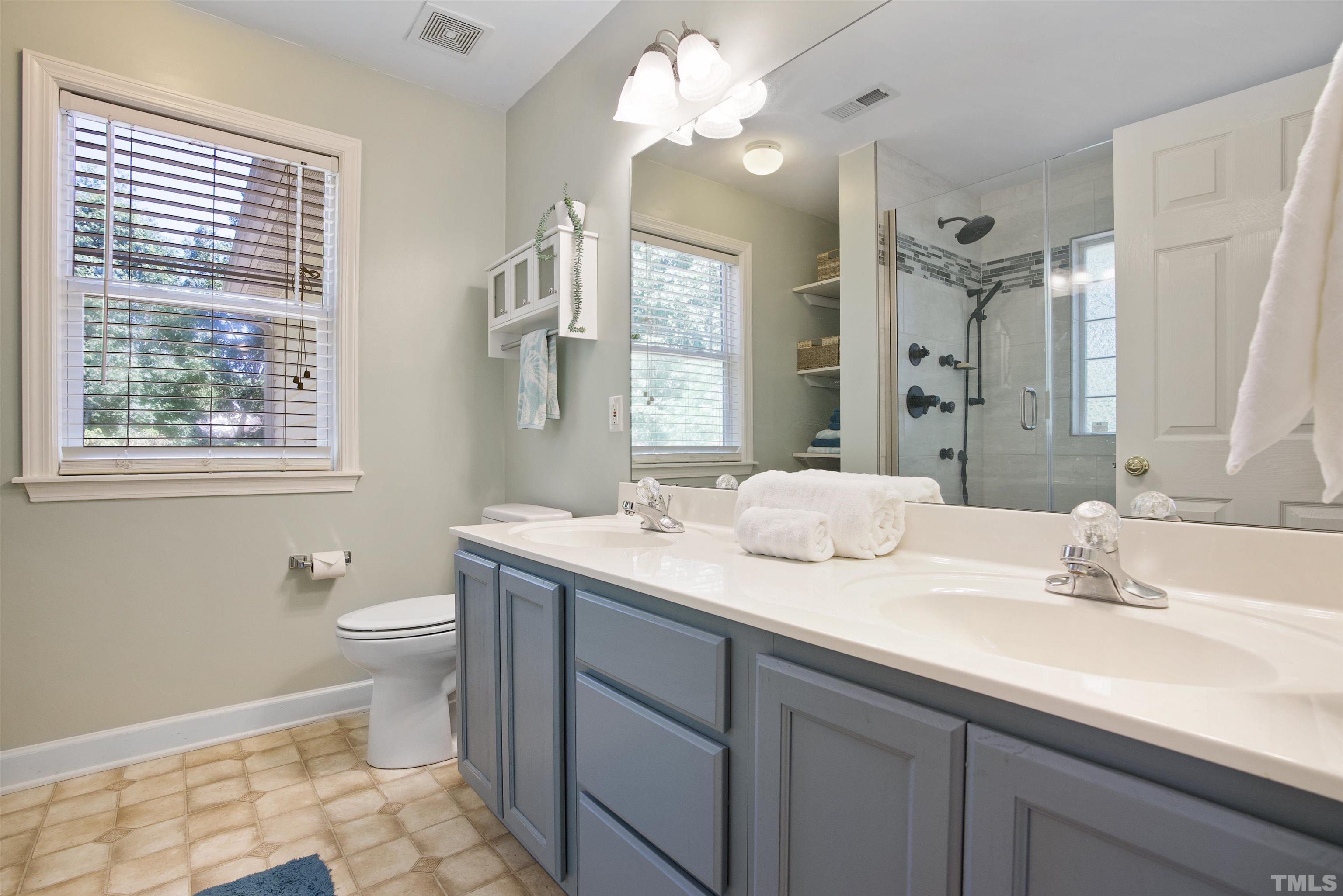 3421 Suncrest Village Lane Raleigh, NC 27616 - Photo 25 of 29 a bathroom with a double vanity sink a toilet and a mirror