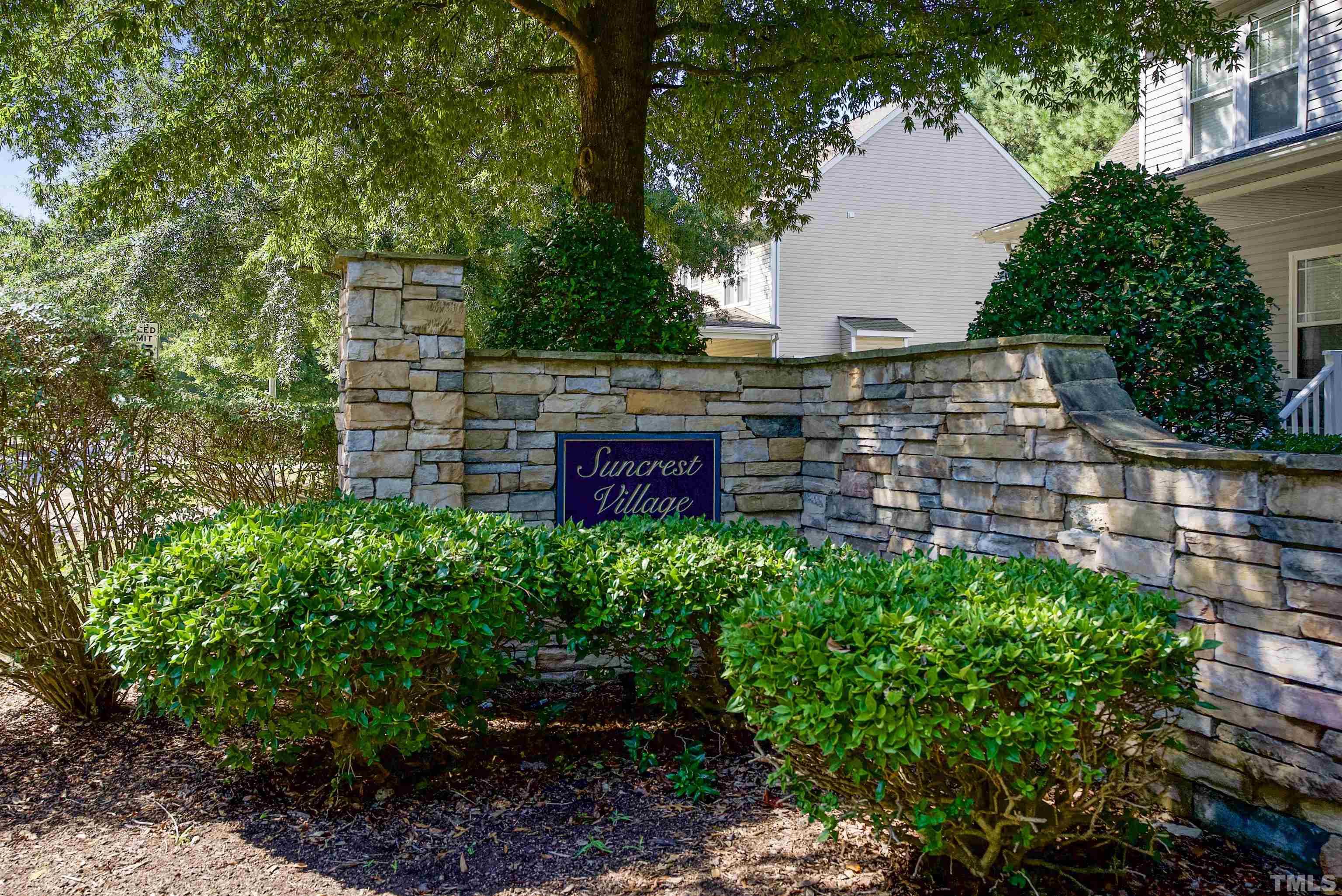 3421 Suncrest Village Lane Raleigh, NC 27616 - Photo 28 of 29 a view of a brick wall with plants and trees