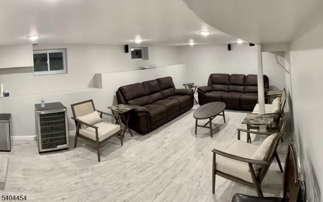 a living room with furniture a flat screen tv and kitchen view