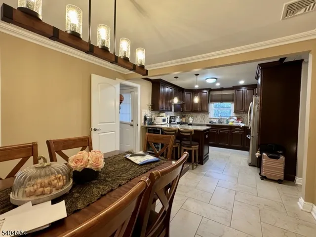 a kitchen with kitchen island a counter top space a sink stainless steel appliances and cabinets