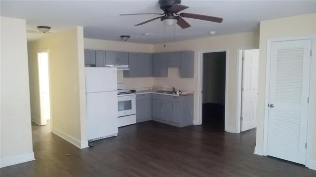 a view of a kitchen with refrigerator and wooden floor