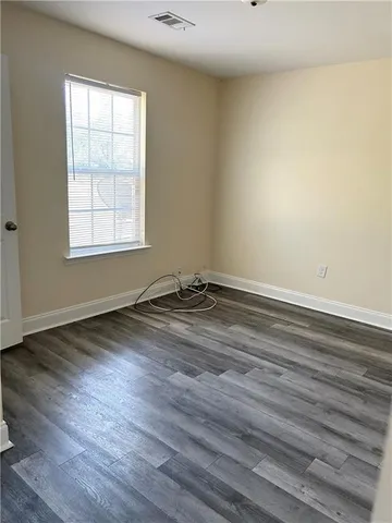 a view of a room with wooden floor and window