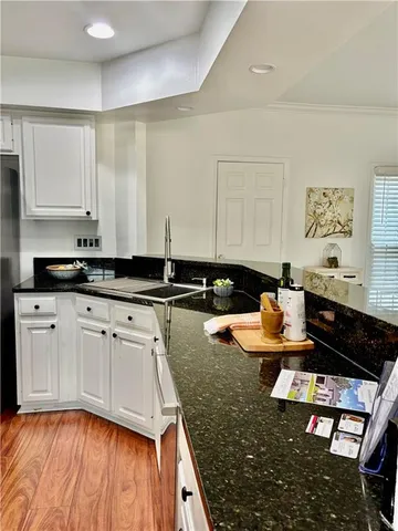 a bathroom with a granite countertop sink a toilet and a shower curtain