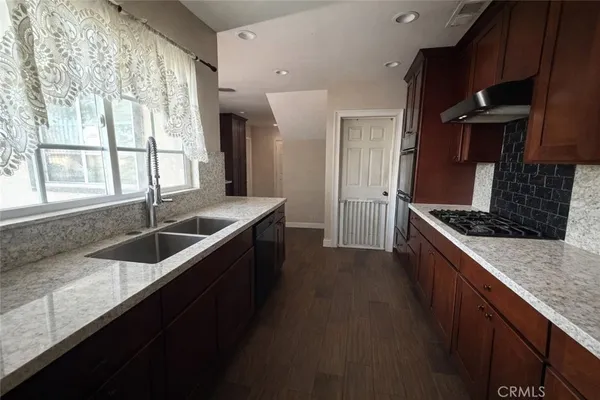 a kitchen with granite countertop a sink and a stove