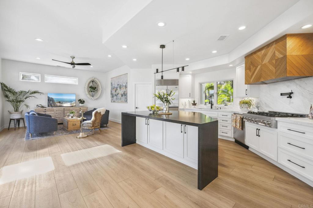 3443 Country Road Fallbrook, CA 92028 - Photo 20 of 71 a kitchen with stainless steel appliances kitchen island granite countertop a sink dishwasher a stove and a dining table with wooden floor