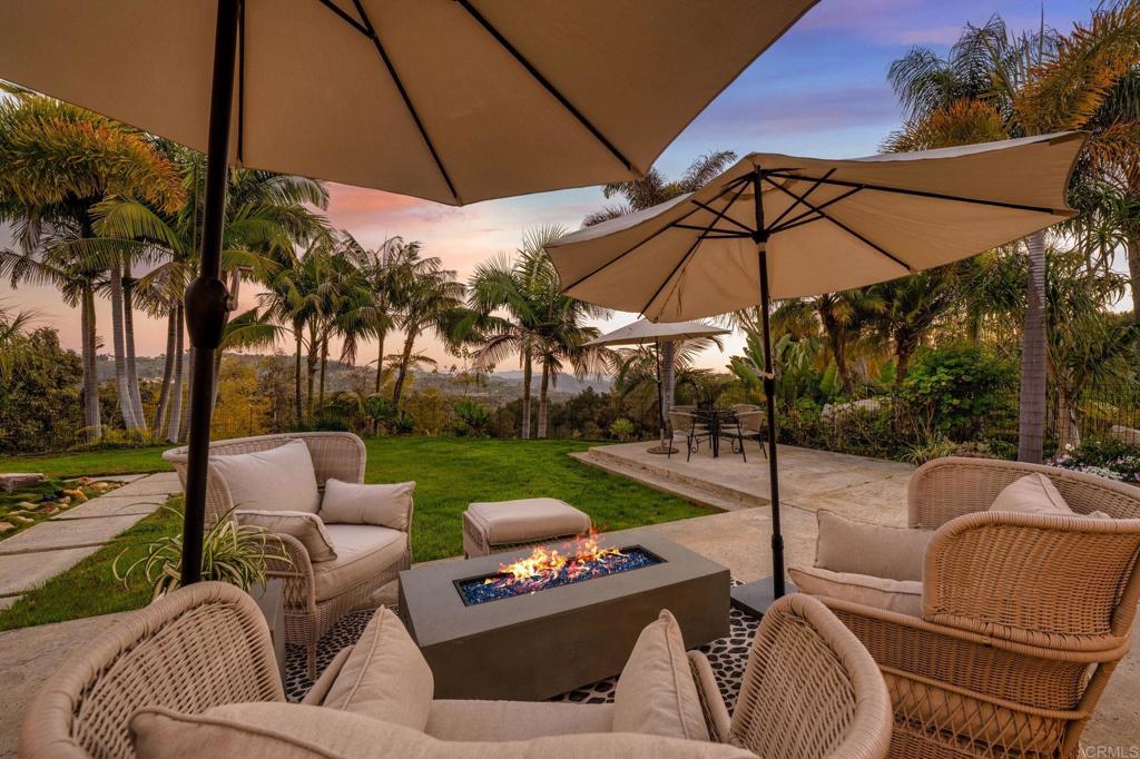 3443 Country Road Fallbrook, CA 92028 - Photo 63 of 71 a view of a backyard with couches table and chairs under an umbrella