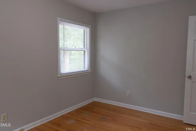 a view of a small space with wooden floor and a window