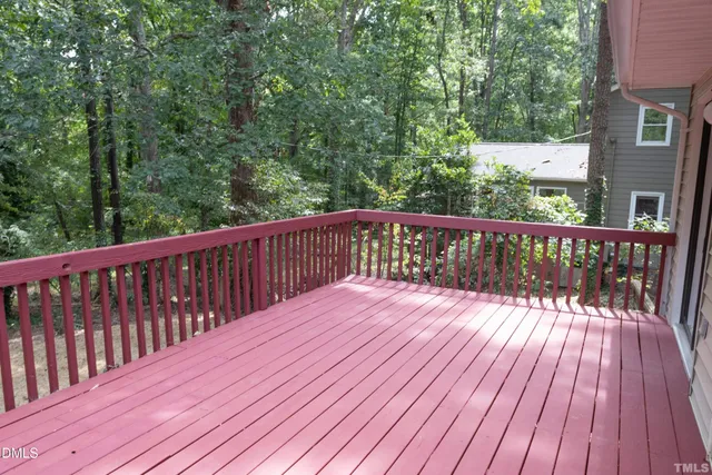 a balcony with wooden floor and trees