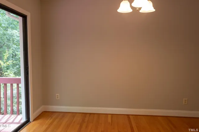 a view of a small space with wooden floor and a window