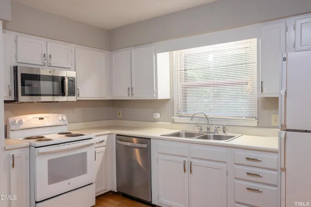 a kitchen with appliances a sink and a window