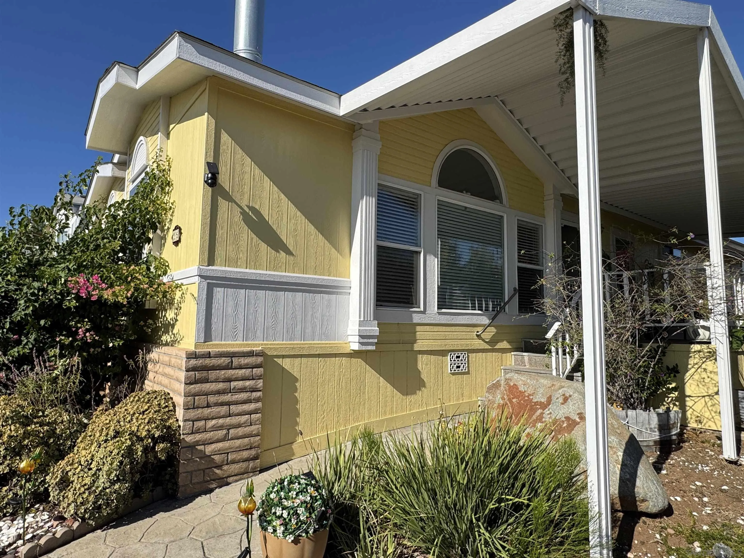12250 Vista Del Cajon Road, Unit 25 El Cajon, CA 92021 - Photo 28 of 39 a front view of a house with a garden